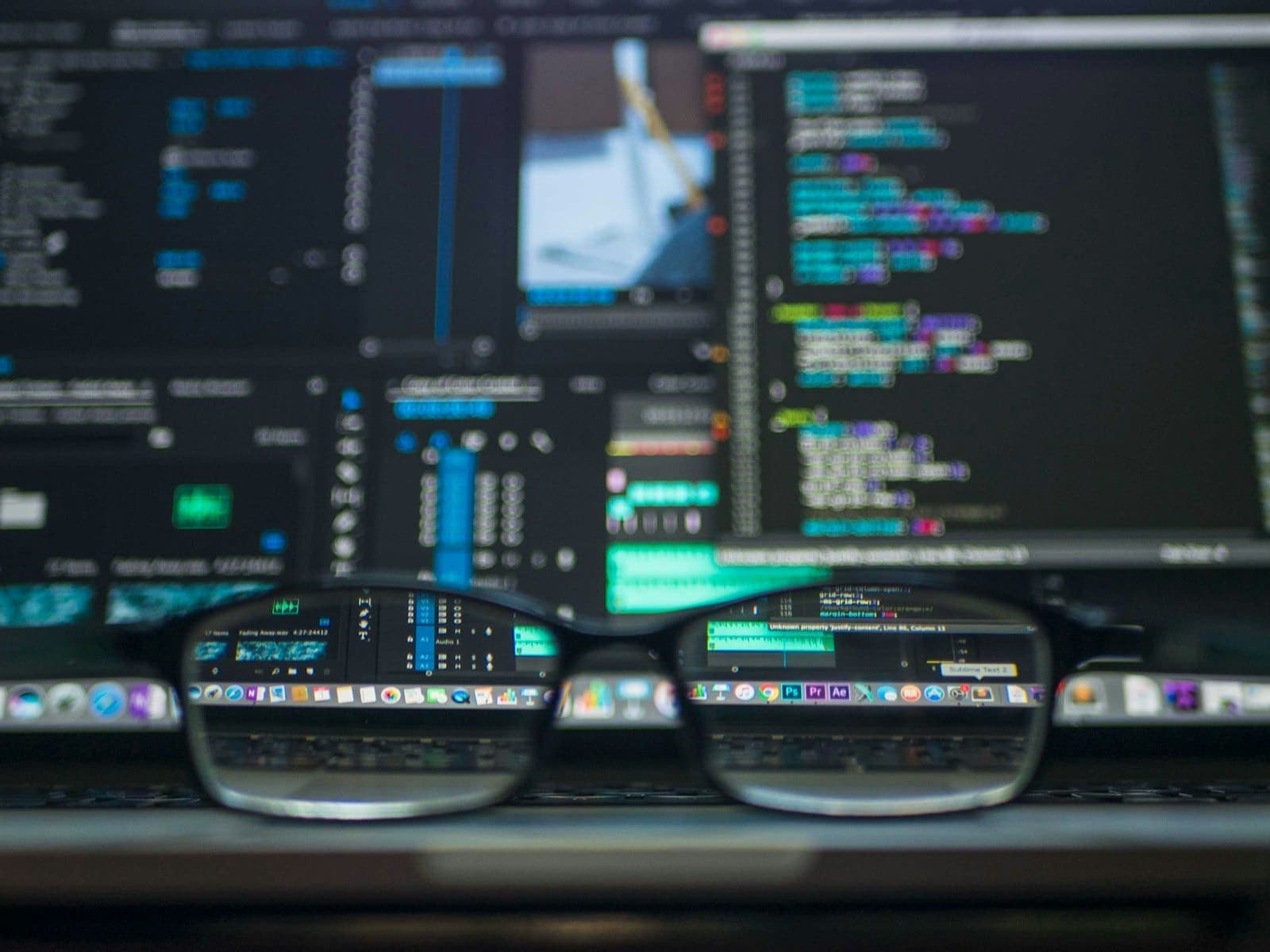 Developer monitors displaying code and data visualisations